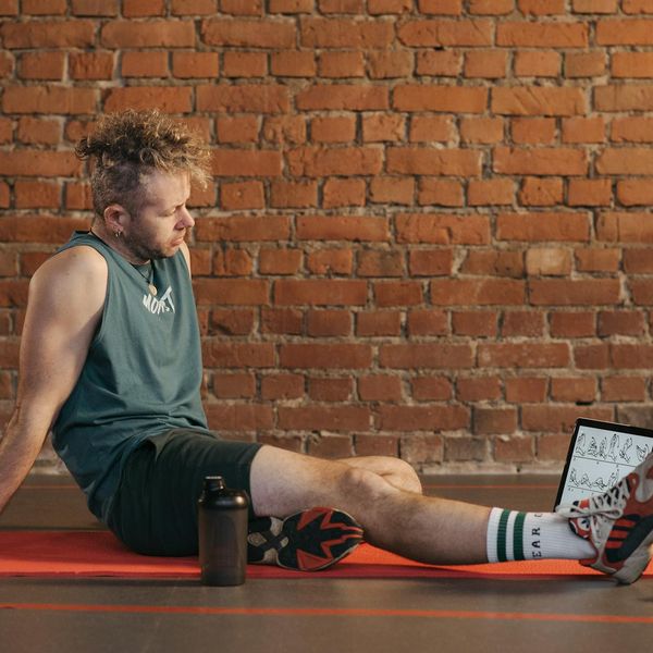 Person meditating peacefully after a workout session with soft light in the background.